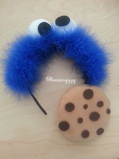 a close up of a stuffed animal with blue fur and black dots on it's ears