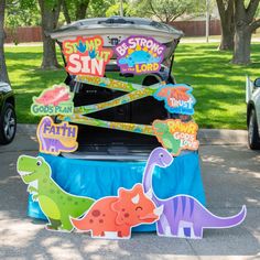 the trunk of a car is decorated with dinosaur magnets and stickers on it