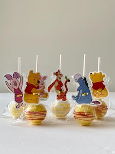 winnie the pooh cake pops are in plastic wrappers on top of each other