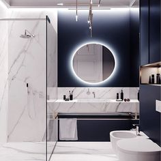 a bathroom with marble walls and flooring, including a round mirror above the sink