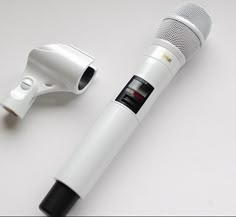 a white microphone and an electric hair dryer sitting next to each other on a table