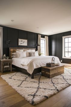 a large bed sitting on top of a wooden floor next to a white and black wall