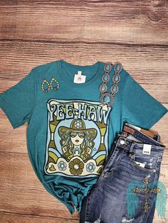 Feel confident and stylish in our Turquoise Yee Haw Cowgirl Tee. Made with a soft and breathable bella canvas fabric, this tee adds a pop of color to any outfit. Perfect for everyday wear or a night out. Turquoise Fitted Short Sleeve Top, Fitted Turquoise Short Sleeve Tops, Bohemian Blue T-shirt With Graphic Print, Bohemian Blue Graphic Print T-shirt, Blue Bohemian Graphic Print T-shirt, Turquoise Short Sleeve Tops For Spring, Hippie Soft-washed Cotton T-shirt, Blue Bohemian Cotton T-shirt, Casual Turquoise Top For Spring