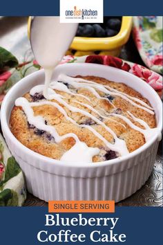 a blueberry coffee cake is being drizzled with icing on top