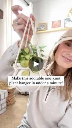 a woman holding up a plant in her hands with the caption make this adorable one - knot plant hanger under a minute