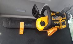 a yellow and black cordless saw sitting on the back seat of a car