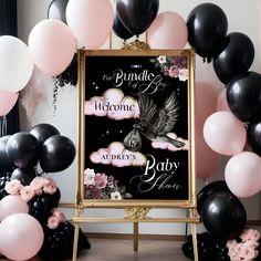 a welcome sign surrounded by balloons and streamers in black, pink, and white colors