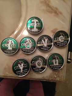 six green and white badges on the side of a refrigerator