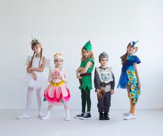 five children dressed up in costumes posing for a photo with their hands on their hips