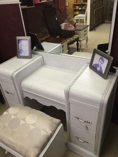 a white dressing table with a mirror and stool