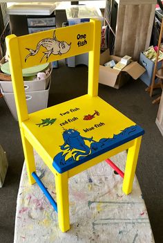 a child's yellow chair sitting on top of a rug