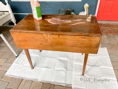 a wooden table with a bottle on it and a rug in front of the door