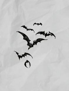 four bats flying in the air on white paper