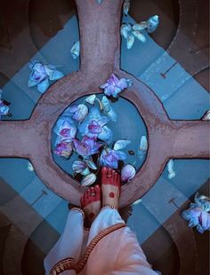 a person standing in front of a cross with flowers on it