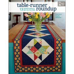 a table runner with flowers in a vase on top of it and the words table runner roundup written below