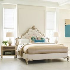 a bedroom with white furniture and blue accents on the walls, along with two chairs