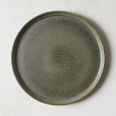 a green plate sitting on top of a white table