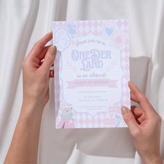 two hands holding up a pink and white birthday card that says, it's an older land as we celebrate