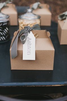 small boxes with ribbons and tags on them are sitting on a table next to some jars