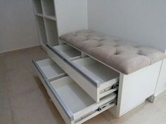 a white dresser with two drawers and a bench in the middle is shown, it's open