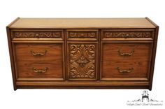 an ornately carved wooden dresser with drawers