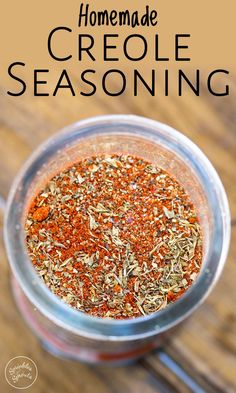 homemade creole seasoning in a glass jar on a wooden table with text overlay