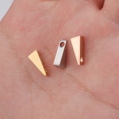 two small pieces of metal sitting on top of a persons hand in front of the camera