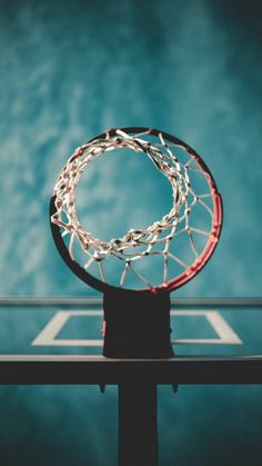 a basketball hoop that is on top of a table in front of a blue wall