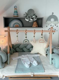 a child's bed with lots of pillows and toys on it in a room