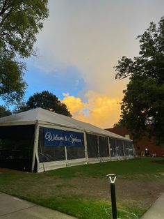 a large tent set up on the side of a road with trees in the background