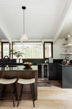 a kitchen with two stools and an island