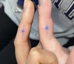 two fingers with blue stars painted on them