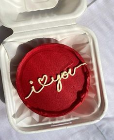 a red cake with the word i love you written on it in a white box