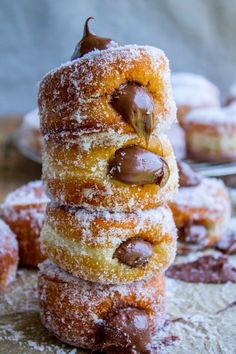 several donuts stacked on top of each other with powdered sugar and chocolate toppings