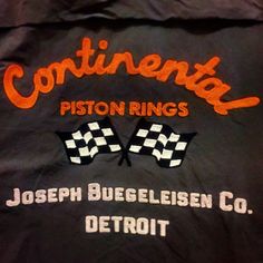 the back of a black jacket with orange writing on it that says continental piston rings joseph bueckelsen co detroit