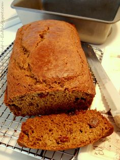 a loaf of banana bread sitting on top of a cooling rack next to a pan