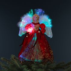 an angel ornament on top of a christmas tree