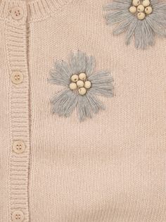 a sweater with two flowers on the front and one flower on the back, as well as buttons