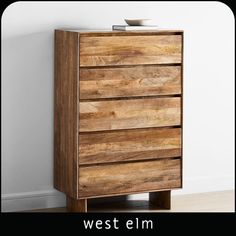 a wooden chest of drawers sitting on top of a hard wood floor next to a white wall