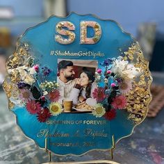 a blue plate with a couple holding each other and flowers in the middle on a table