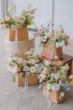 three wicker baskets with flowers in them