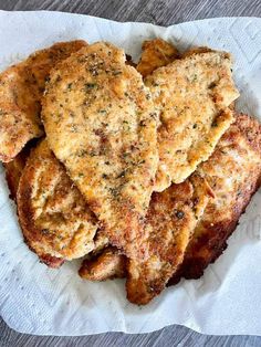 four pieces of fried food sitting on top of a white paper towel covered in seasoning