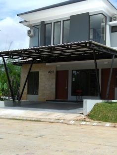 a modern house with an attached carport in the front yard and covered patio area