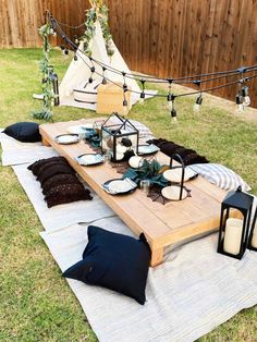 a picnic table set up with plates, candles and other items on top of it