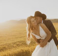 a bride and groom kissing in the middle of an open field with sun shining on them