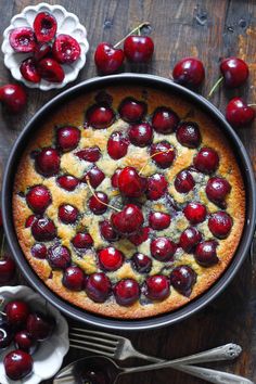 a cherry cobbler cake with cherries and a whisk