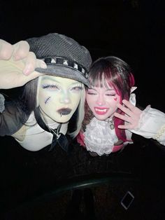 two people dressed in costumes posing for the camera at an event with their faces painted white and black