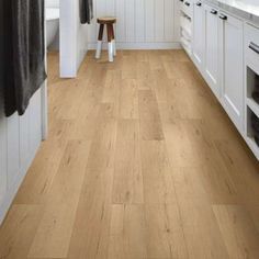 a kitchen with white cabinets and wood floors