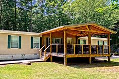 a mobile home with a covered porch in the front yard