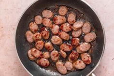 sausages are cooking in a skillet on the stove top, ready to be cooked